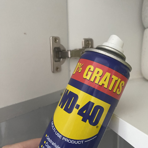Szekrény zsanér kenése WD-40el a nyikorgás ellen